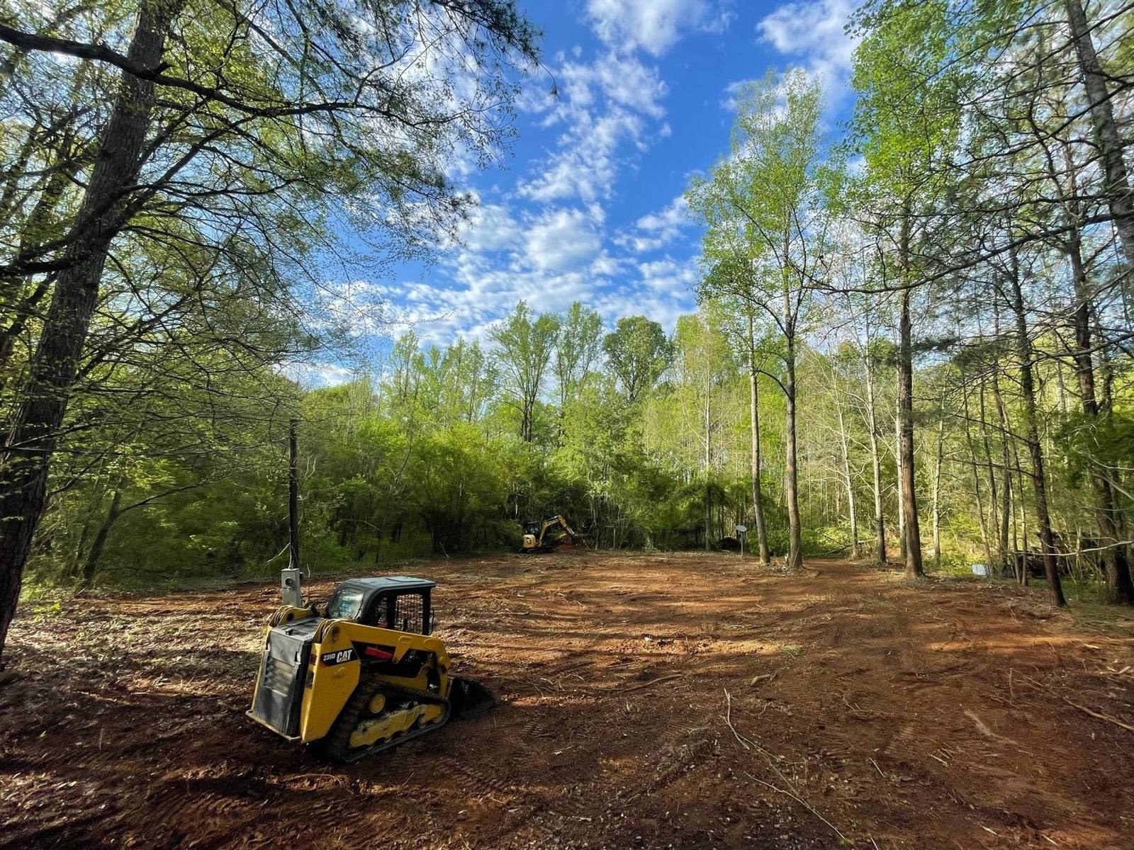 Compact track loader grading a cleared lot